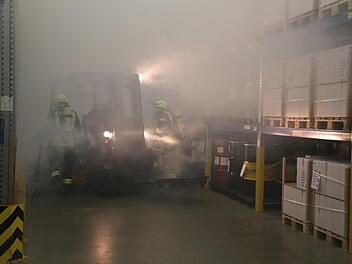 In der verqualmten Halle gingen Feuerwehrleute gegen den angenommenen Brandherd vor. Foto: B. Kleinschmidt