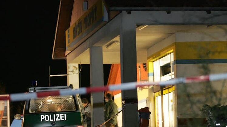 Polizeibeamte sichern nach dem Mord an Norbert Ottinger vor dem Supermarkt Spuren, darunter die DNA des Täters.  Foto: Archiv