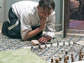 Über Wochen und Monate bleibt Bartok (Oliver Masucci) in der Isolationshaft standhaft, verzweifelt jedoch zusehends - bis er durch Zufall an ein Schachbuch gerät.
