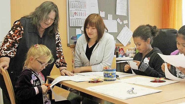 Trotz beschlossener Gebührenerhöhung bleibt die Nachmittagsbetreuung in Weidhäuser Grundschule relativ günstig: Betreuerin Helga Winzer (links stehend) und Kinderpflegerin Lisa Schindhelm helfen (von links) der sechsjährigen Pauline, der zehnjährigen Alisha und der neunjährigen Lynlyn beim Ausschneiden von Mandalas. Foto: Thomas Heuchling