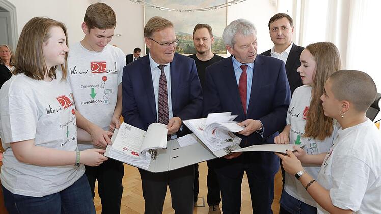 Die Schüler des Dientzenhofer-Gymnasiums Anna, René, Marie und Joana (von links) übergeben Andreas Starke und Landrat Johann Kalb vor der Zweckverbandssitzung Unterschriften gegen eine DG-Verlagerung. Hinten v.l.: Elternbeiräte Günter Helmrich und Christoph Trué.  Foto: Matthias Hoch