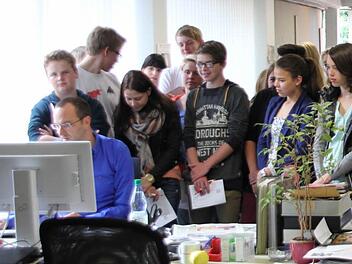 Alexander Löffler (sitzend) erklärt den Gymnasiasten, wie die Ausgabe des nächsten Tags am PC geplant wird. Foto: Marco Meißner