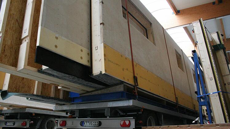 Holzwandteile, fertig verladen auf einem Lkw-Anhänger.