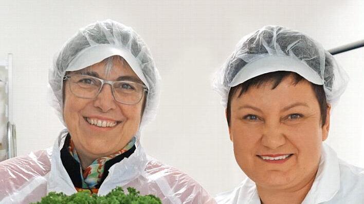 Regionalbischöfin Dorothea Greiner (links) und die Betriebsleiterin der "Menüfaktur", Marina Lofink, mit einem Riesenbund Petersilie Foto: privat