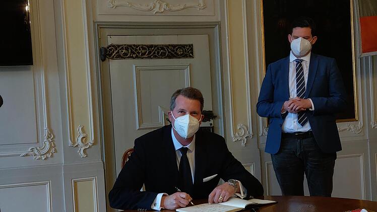 Erbprinz Hubertus von Sachsen-Coburg und Gotha (sitzend) und Oberbürgermeister Dominik Sauerteig trugen sich als erste in das Kondolenzbuch für Prinz Philip ein. Foto: Simone Bastian