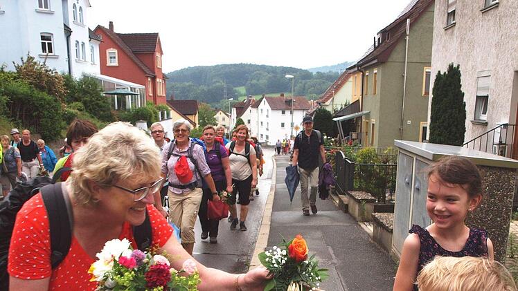 Traditionell werden die Wallfahrer von ihren Angehörigen bei ihrer Rückkehr mit einem Blumenstrauß freudig begrüßt. Diese Frau erhielt gleich mehrere Sträuße.Foto: Alfred Thieret