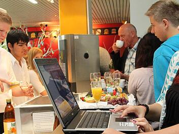 Mit modernen  Medien  an der  Kaffeebar:      Justine  (rechts), die beim Bau  des Schüler-Cafés   geholfen hat, wirft einen Blick in den  Computer.   Maximilian und Emre (von links) gehören zum Team  der künftigen  Achtklässler, die das  Café  betreiben werden.  Foto:  Alexander Hartmann