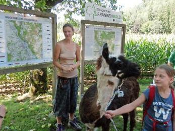 Tanja Sünkel umringt von den Kindern und Lamas an der Wandertafel bei der Schneidmühle Foto: privat