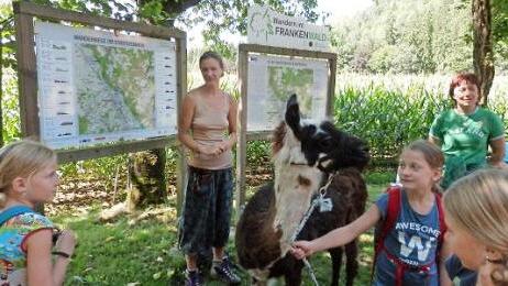 Tanja Sünkel umringt von den Kindern und Lamas an der Wandertafel bei der Schneidmühle Foto: privat