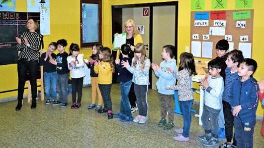 Margot Schmitt (links) übergab die Urkunde an Klasslehrerin Ulrike Brandl. Mit im Bild Rektorin Daniela Naujoks (Mitte) und einige Kinder  Foto: Werner Reißaus