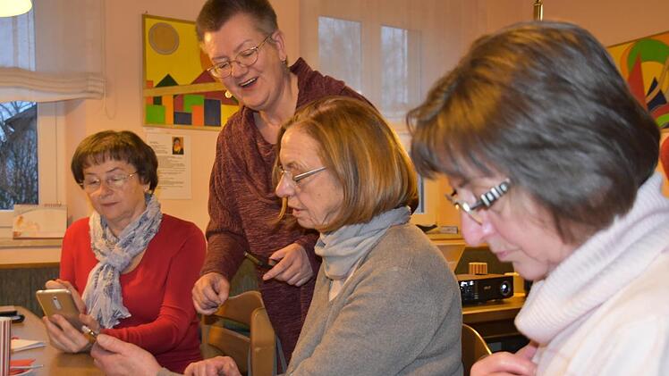 Kursleiterin Beate Oehrlein (stehend) zeigt Maria Wagner, Gisela Erlmann und Heidi Wich, dass der Umgang mit dem Smartphone keine Hexerei ist. Foto: Uschi Prawitz