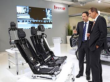 Der Vorsitzende der Brose Geschäftsführung, Jürgen Otto, erklärt Klaus Draeger, Mitglied des Vorstands der BMW AG, am IAA-Stand in Frankfurt die Brose-Rücksitzstruktur. Foto: Brose