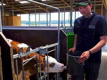 Prüfung am lebenden Objekt: Der angehende Landwirt-Facharbeiter Andre Schneider stillt einem Kalb im Milchviehstall von Adrios Florianshof den Durst. Foto: Gerd Schaar