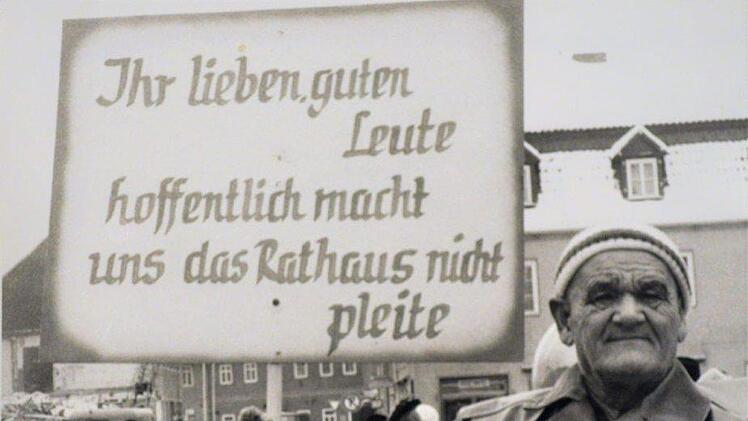 Mit einem Spruchschild machte am Faschingsdienstag 1969 Dachdecker Paul Wege auf die hohen Kosten für den Rathausneubau aufmerksam.