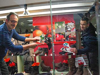 Mit den verschiedenen Aktionen versuchen die Münnerstädter Geschäftsleute Kunden in die Stadt zu locken. Das Weihnachts-Gewinnspiel läuft sehr gut. Hier schmücken Michael Moritz und Arno Reuscher ein Schaufenster. Bald wird es noch mehr geben, denn für zwei Jahre wird der Gewerbeverein unterstützt. Archiv/Christine Schikora