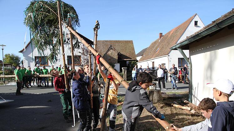 Der Kinderbaum wird aufgestellt. Die großen Kerwasburschen (hinten) schauen noch zu. Foto: Mathias Erlwein