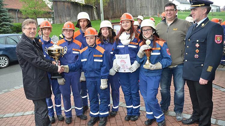 Bürgermeister Rainer Detsch überreichte der siegreichen Jugendfeuerwehr aus Stockheim den Gemeinde-Cup. Das Bild zeigt (von links): Bürgermeister Rainer Detsch, Julian Schröppel, Patrick Neubauer, Felix Schwabe, Nico Friedrich, Eva Barnickel, Laura Wittmann, Luisa Rebhan, Jugendwart Andre Korn und Kreisbrandrat Joachim Ranzenberger.