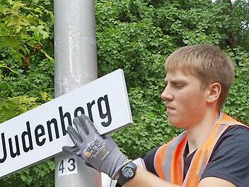 Phillip Thumser befestigt ein Straßenschild neu, das von Vandalen beschädigt worden war. Fotos: Rainer Lutz