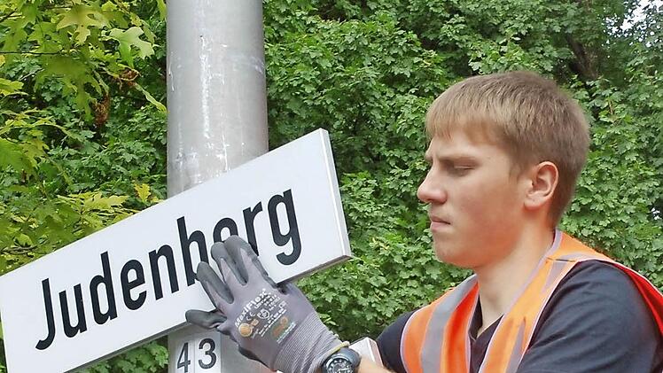Phillip Thumser befestigt ein Straßenschild neu, das von Vandalen beschädigt worden war. Fotos: Rainer Lutz