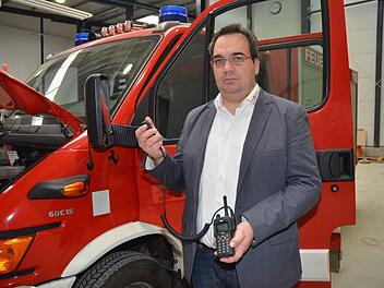 Dirk Schult zeigt das Handsprechfunkgerät HRT mit Faustmikrofon. Die Anordnung der Tasten ist bei allen Geräten gleich, ob beim Fahrzeuggerät oder beim Handsprechfunkgerät. Foto: Karl-Heinz Hofmann