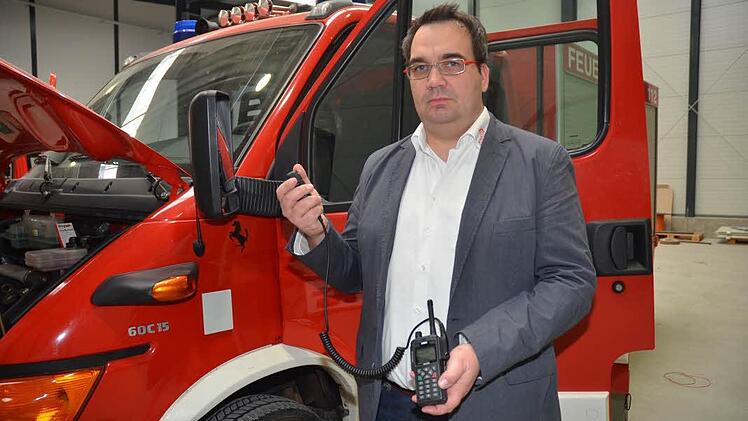Dirk Schult zeigt das Handsprechfunkgerät HRT mit Faustmikrofon. Die Anordnung der Tasten ist bei allen Geräten gleich, ob beim Fahrzeuggerät oder beim Handsprechfunkgerät. Foto: Karl-Heinz Hofmann
