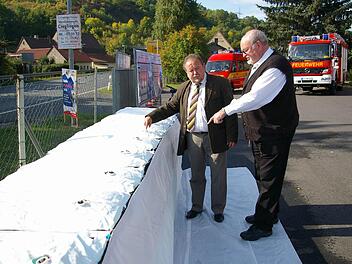 Der Damm hält: Bürgermeister Erich Hegwein und Geschäftsführer Karl Orth begutachten die mit Wasser gefüllte Staumauer von der Seite aus, von der das Hochwasser kommen würde.  Fotos: Tom Müller