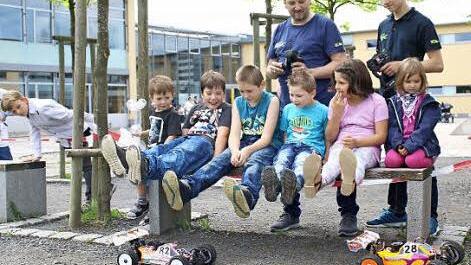 Achtung, Füße hoch! Als die kleinen ferngesteuerten "Buggys" unter ihrer Bank fuhren, machten die jungen Gäste ganz schnell Platz. Hinten Ralf (links) und sein Sohn Jonas Bauer vom "RC Car Buggy Team" des Motorsportclubs (MSC) Sand.  Fotos: Ralf Naumann