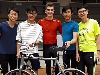 Lukas Kohl (M.) und der Kunstrad-Tross aus Hongkong: Als Gastgeschenk bekam der Weltmeister beim Weltcup in Heerlen einen kleinen Stoff-Pandabären überreicht  (siehe Fahrrad). privat