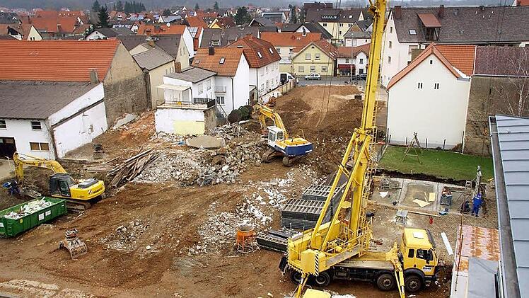 Das L-förmige Areal, auf dem die beiden Bagger und der Kran stehen, ist der Baugrund für die Marktscheune. Das Bild wurde vom Dach der Sparkasse aus aufgenommen.  Foto: Heidi Wolf