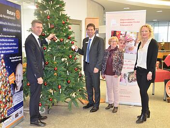 Stefan Müller und Roland Stopfer befestigen ihre Wünsche am Baum. Der Erlös geht diesmal an die Elterninitiative krebskranker Kinder aus Erlangen, vertreten durch Christine Träg und Christine Habermann (von links)  Foto: Bernnhard Panzer