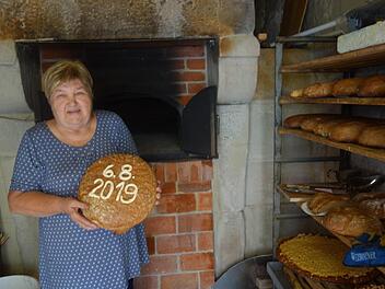 Renate Kissinger präsentiert eines der ersten Brote, die im Schlettacher Backhaus gebacken wurden. Foto: Doris Weidner