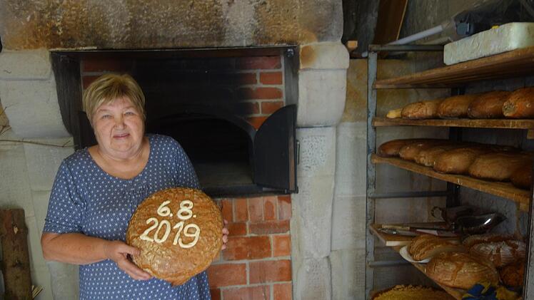 Renate Kissinger präsentiert eines der ersten Brote, die im Schlettacher Backhaus gebacken wurden. Foto: Doris Weidner