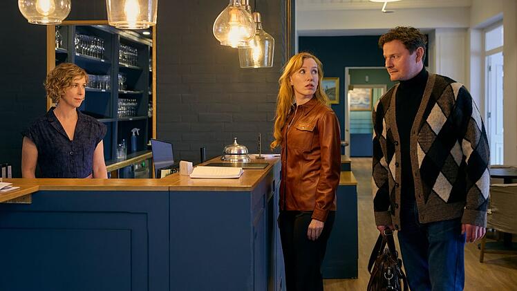 Janne (Brigitte Zeh, links) staunt nicht schlecht, als sie sieht, wer der Mann ihres neuen Hotelgastes Mette (Christin Nichols) ist: ihr Ex-Partner Jesper (Shenja Lacher), auf den sie alles andere als gut zu sprechen ist.