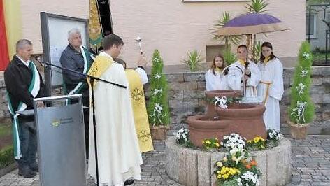 Pfarrer Matthias Steffel weiht den Brunnen. Foto: Mathias Erlwein