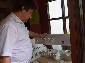 Pfarrer Jörg Herrmann anhand eines Modells, was an der Kirche alles geändert werden soll. Foto: Daniela Pondelicek