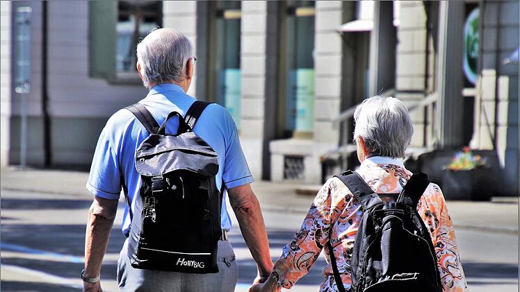 Ältere Mann und Frau gehen Hand in Hand.