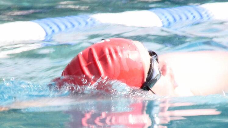 Ein Schwimmer nimmt einen tiefen Atemzug, um genug Sauerstoff für die nächsten, kraftraubenden Züge zu tanken.