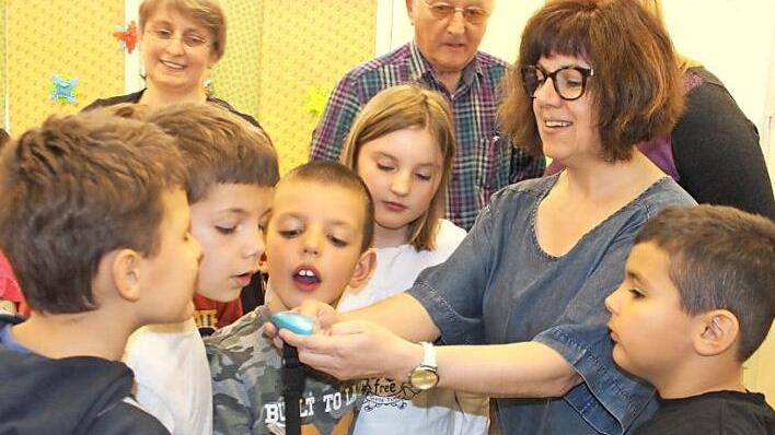 Tina Lauer wiegt das Säckchen mit den Plastikdeckeln ab und lässt die Kinder das Gewicht raten. Im Hintergrund verfolgen Helene Sabelfeld und Hendrik Seegebarth die Aktion.  Fotos: Bernhard Panzer