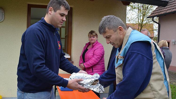 Ein Blick nach draußen: Hier nimmt der Wollbacher Kurt Rottenberger (rechts) seinen Einkauf von Christian Rost in Empfang. Foto: Kathrin Kupka-Hahn