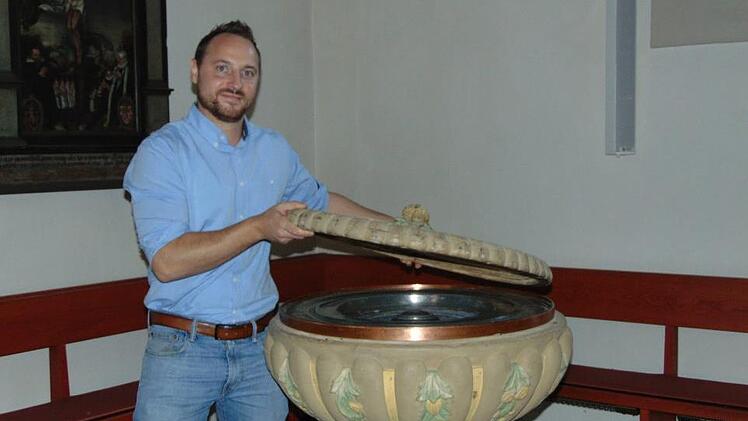David Vogt am Taufbecken der Dreieinigkeitskirche in Gräfenberg Foto: Petra Malbrich