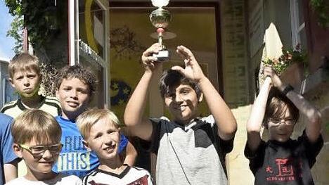 Stolz nahm die Mondgruppe den Pokal für den Sieg im Fußballturnier entgegen. Necirvan hebt den Pokal in die Höhe. Mit ihm freuen sich (in der gleichen Reihe von links): Marco, Elias und David.  Foto: Gerold Snater