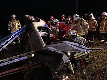 Die Feuerwehrleute setzen das Werkzeug an, um die eingeklemmte Frau aus dem Autowrack zu befreien. Foto: Josef Hofbauer