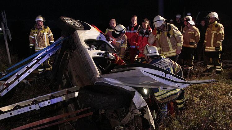 Die Feuerwehrleute setzen das Werkzeug an, um die eingeklemmte Frau aus dem Autowrack zu befreien. Foto: Josef Hofbauer