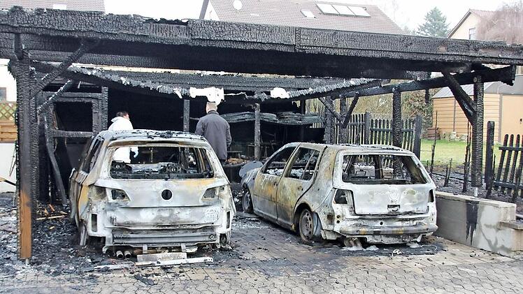 Zwei VW Golf brannten in dem Carport in der Ermershäuser Hauptstraße mit aus. Auch der Zaun zum Nachbaranwesen ging in Flammen auf. Am Dienstagmorgen waren Brandermittler der Kripo Schweinfurt damit beschäftigt, die Brandursache ausfindig zu machen.  Foto: Ralf Kestel