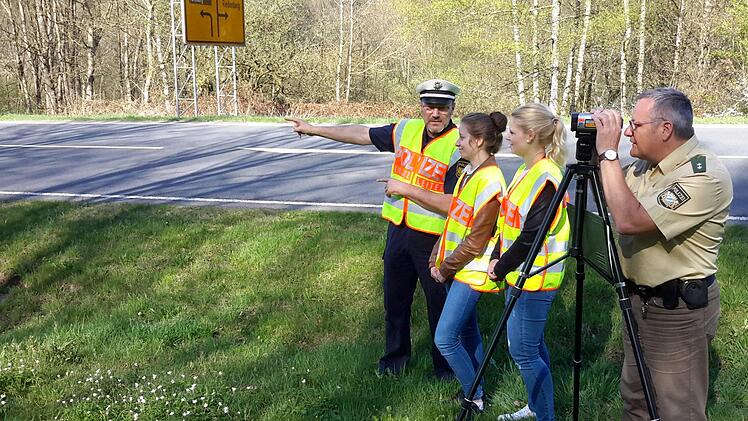Der Leiter der Polizeiinspektion Bad Brückenau, Herbert Markert, erläutert den beiden Auszubildenden Maja Gundelach und Vanessa Wießner (von links) im Detail, wie die Geschwindigkeitsmessung mit dem Lasergerät funktioniert. Oberkommissar Klaus Wiesler (rechts) hat zur gleichen Zeit schon etwaige Temposünder auf der Staatsstrasse 2289 bei Riedenberg im Visier. Rolf Pralle