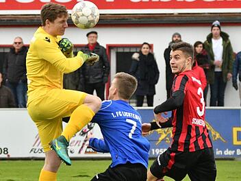 Rettung an der Strafraumgrenze: Der Memmelsdorfer Torwart Thomas Schuberth (links) kl&auml;rt per Kopfball vor dem Lichtenfelser Christopher Schaller (Mitte).  Fotos: Gunther Czepera