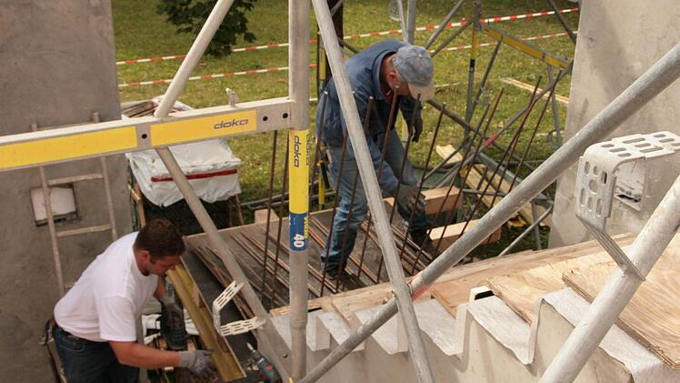 Die Sanierung der Wilhelm-Hegler-Halle in Oerlenbach ist derzeit die größte laufende Baumaßnahme der Gemeinde. René Rosenbaum (links) und Oswald Seit (beide von der Firma Weipert) schalen gerade eine Treppe neue Außentreppe ein. Fotos: Paul Ziegler, Archiv SZ