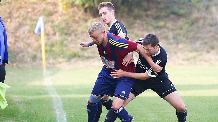Die Haiger Lukas und Andreas Kopp (schwarze Trikots) wollen so lange wie möglich um den Aufstieg mitspielen. Der FC Burggrub um Johannes Grünbeck greift gegen den FC Unter-/Oberrodach nach dem letzten Strohhalm im Abstiegskampf. Foto: Heinrich Weiß,Archiv