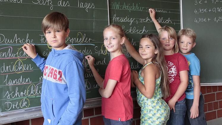 Fünf Schüler der Anna-Grundschule üben an der Tafel die Rechtschreibung. Foto: Hofbauer