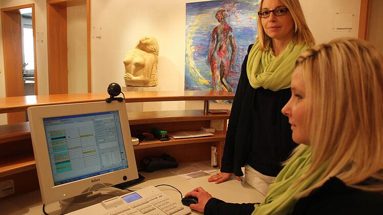 Diana Leicht und Yvonne Schmidt (rechts) kümmern sich in der Praxis von Johannes Bühler um die Terminvergabe. Sie wissen, wie lange bestimmte Untersuchungen dauern, um besser kalkulieren zu können. Ihre Planung machen sie direkt am Computer. Foto: Vanessa Schneider